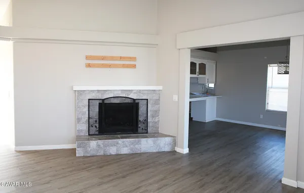 a view of a livingroom with wooden floor and a fireplace
