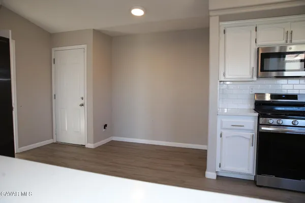 a view of kitchen with granite countertop cabinets and black stainless steel appliances