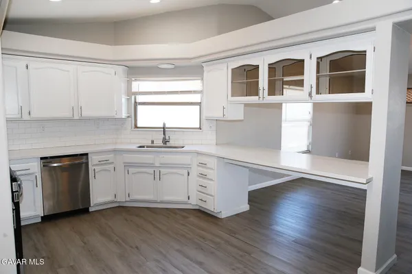 a kitchen with granite countertop white cabinets and white appliances