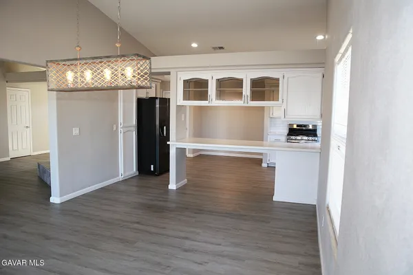 a view of a kitchen with wooden floor and a refrigerator