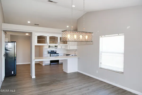 a kitchen with stainless steel appliances granite countertop a refrigerator and a stove top oven