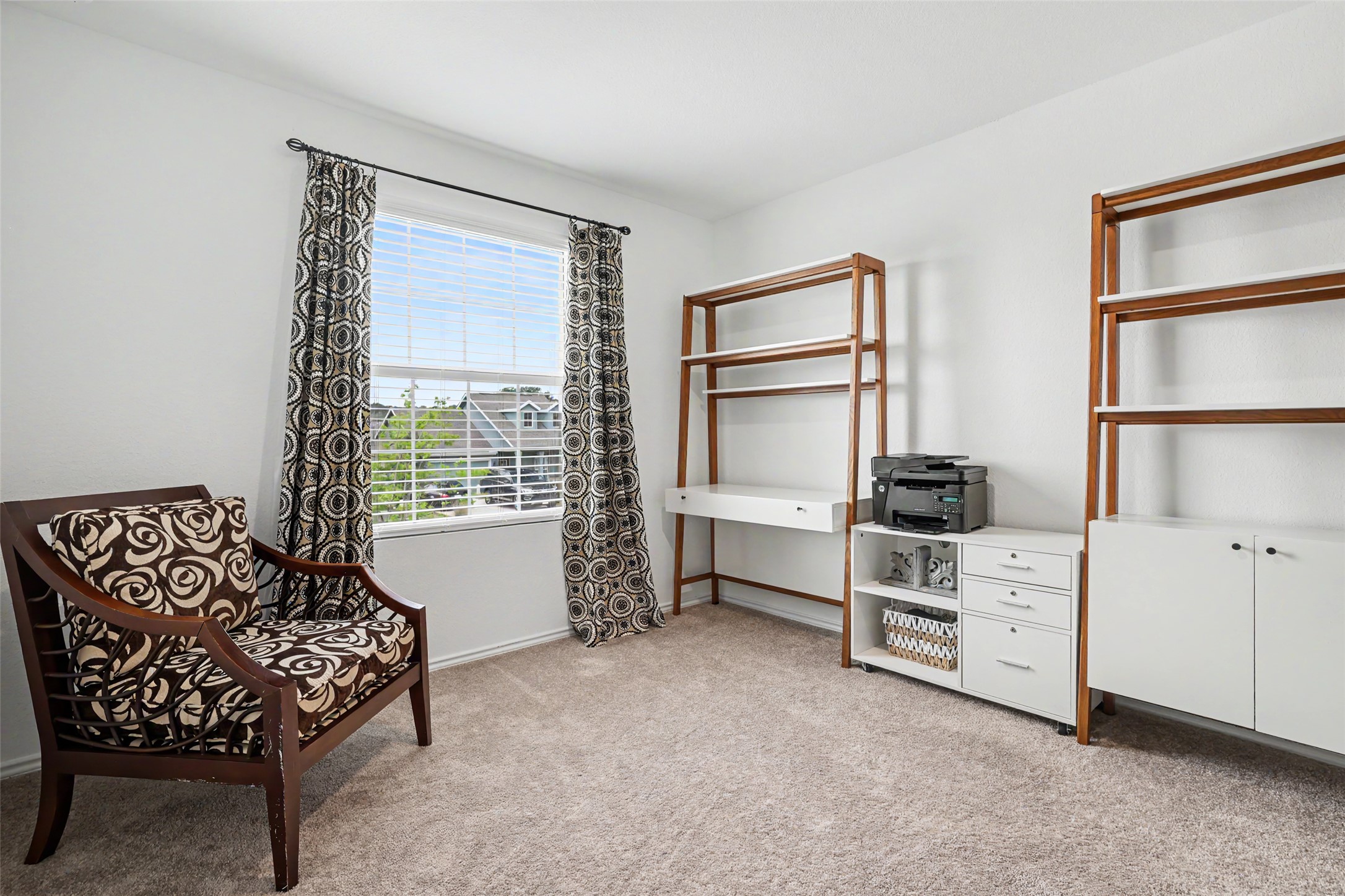 2333 Four Waters Loop Georgetown, TX 78628 - Photo 27 of 35 Carpeted room featuring a large window with blinds, white walls, and built-in shelving units with a desk component
