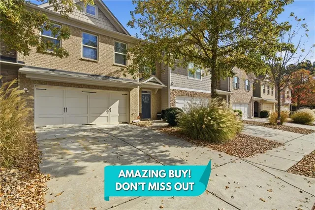 a view of a white house with a large tree next to a yard