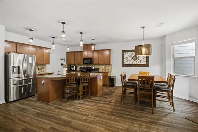 a kitchen with stainless steel appliances granite countertop a sink refrigerator and cabinets