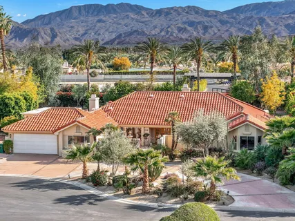 an aerial view of a house with a yard and large trees