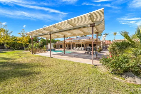 a front view of a house with a yard balcony and outdoor seating