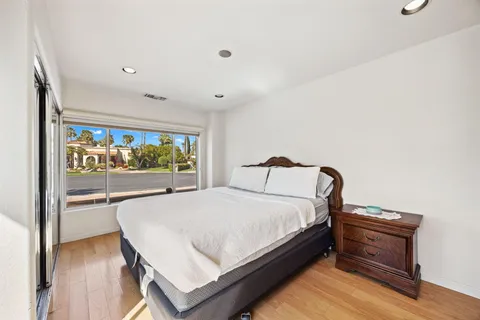 a view of a hallway view with wooden floor and dining room with chandelier