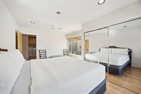 a bed sitting in a spacious bedroom next to a window