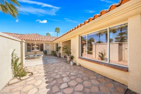 a dining room with furniture and a floor to ceiling window