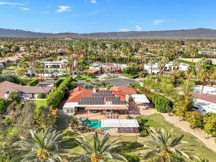 a view of a dining room with furniture large windows a chandelier and chandelier