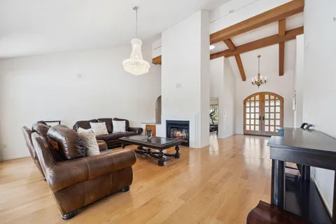 a living room with furniture a flat screen tv and a large window