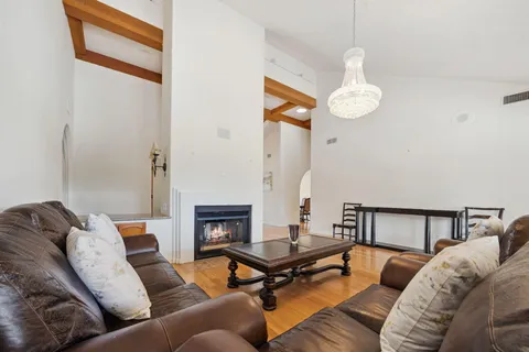 a living room with furniture kitchen view and a large window