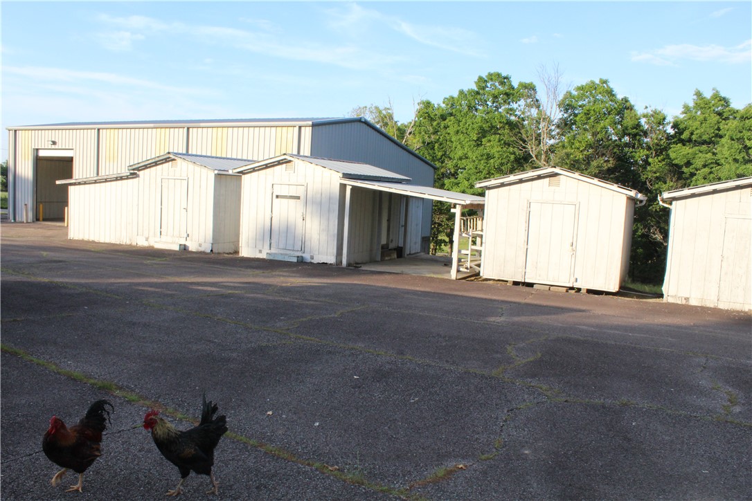 158 Ragon Road Tilly, AR 72679 - Photo 21 of 51 Large metal-sided building with multiple white storage sheds