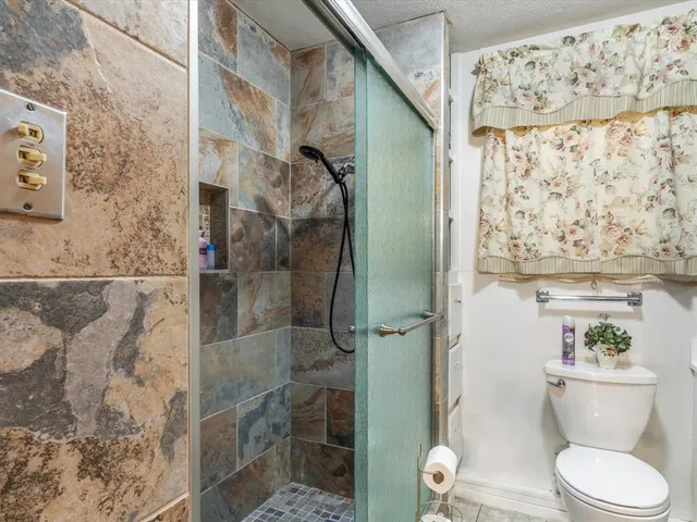 a bathroom with a toilet and a shower