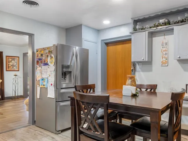 a kitchen with stainless steel appliances a dining table and chairs