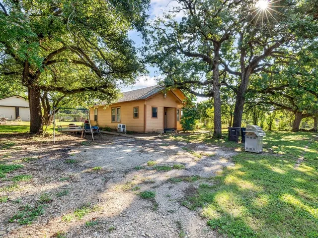 a view of a house with backyard and a tree