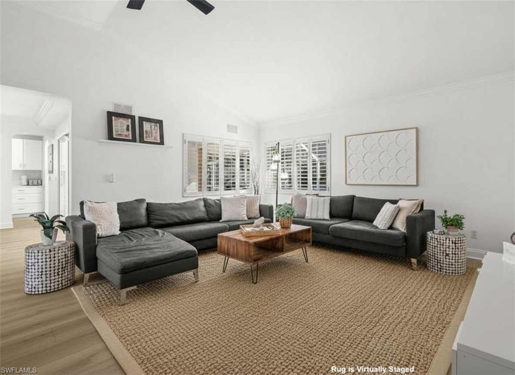 4 Colonial Drive Naples, FL 34112 - Photo 11 of 42 Living area featuring light wood-style floors, ornamental molding, and vaulted ceiling