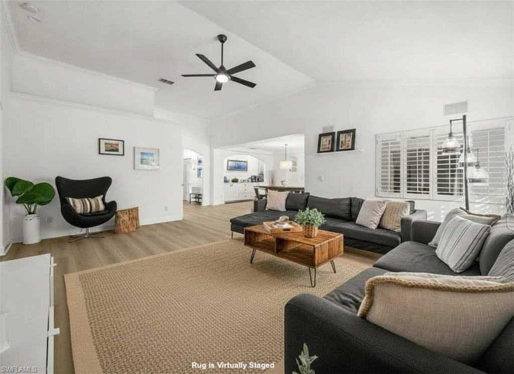 4 Colonial Drive Naples, FL 34112 - Photo 12 of 42 Living room featuring wood finished floors, vaulted ceiling, and ceiling fan