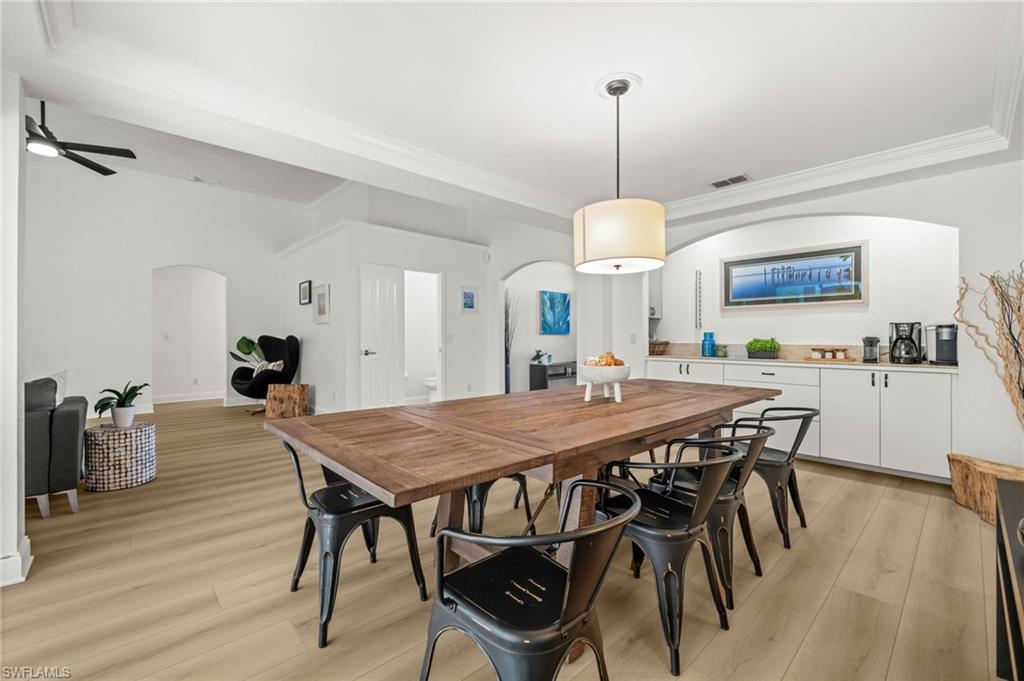 4 Colonial Drive Naples, FL 34112 - Photo 16 of 42 Dining space with arched walkways, light wood-style flooring, ornamental molding, and ceiling fan