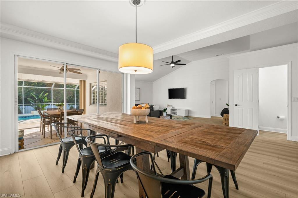 4 Colonial Drive Naples, FL 34112 - Photo 17 of 42 Dining room featuring crown molding, light wood-style flooring, a sunroom, a ceiling fan, and lofted ceiling