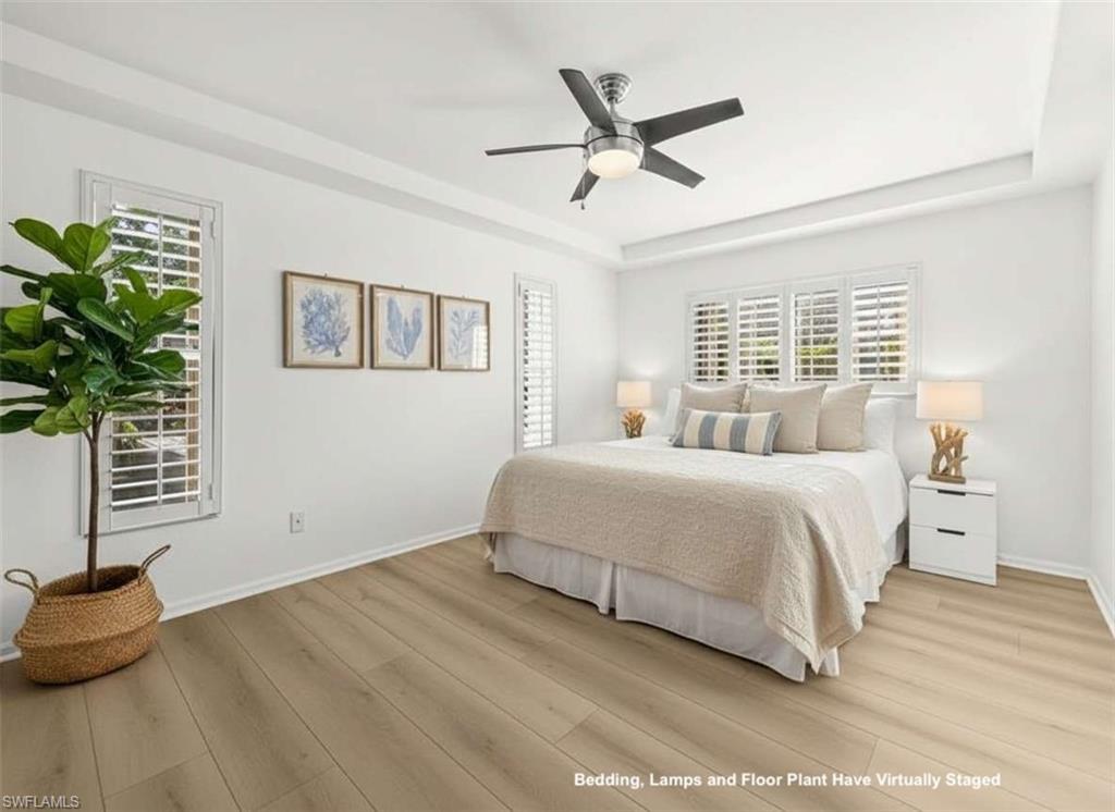 4 Colonial Drive Naples, FL 34112 - Photo 18 of 42 Bedroom featuring a raised ceiling, a ceiling fan, and light wood-type flooring