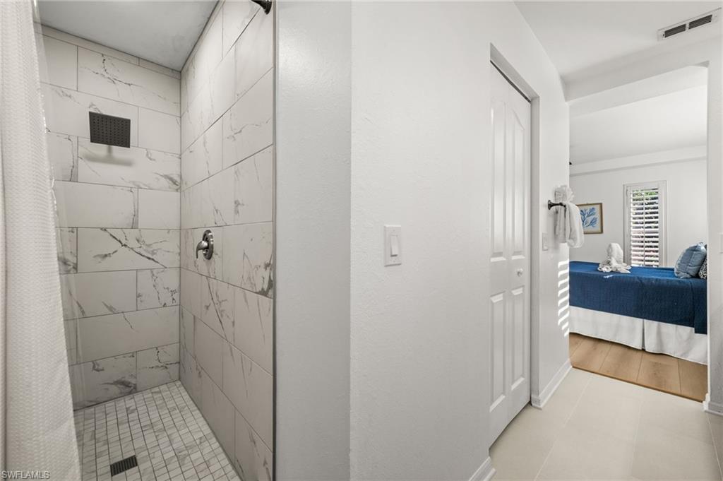 4 Colonial Drive Naples, FL 34112 - Photo 21 of 42 Full bath featuring a stall shower, ensuite bath, and light tile patterned floors