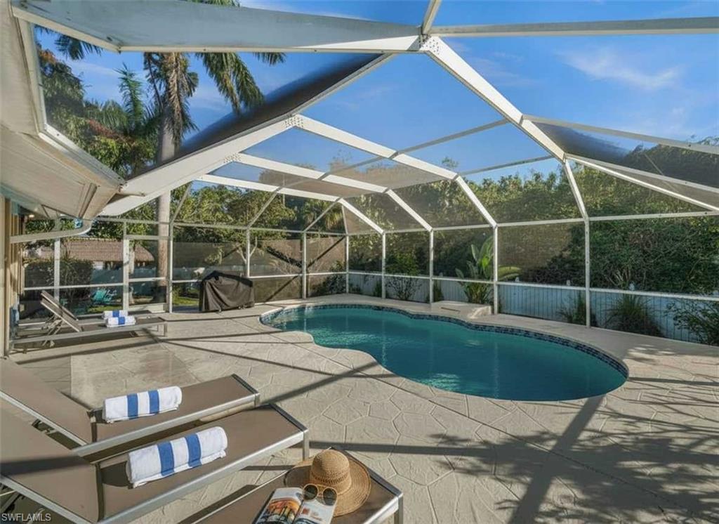 4 Colonial Drive Naples, FL 34112 - Photo 32 of 42 Outdoor pool with a sunroom, glass enclosure, and a patio area