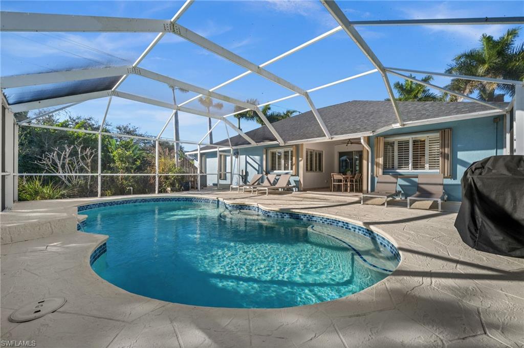 4 Colonial Drive Naples, FL 34112 - Photo 33 of 42 Outdoor pool featuring a sunroom, a patio, glass enclosure, and area for grilling