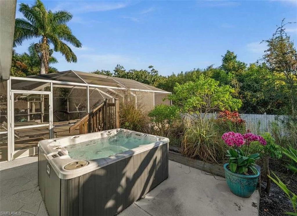 4 Colonial Drive Naples, FL 34112 - Photo 36 of 42 View of patio featuring a lanai, a sunroom, and a hot tub