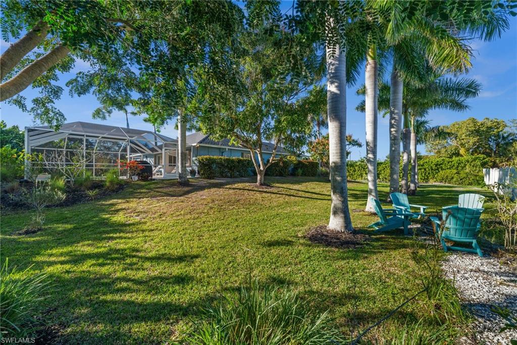 4 Colonial Drive Naples, FL 34112 - Photo 38 of 42 View of grassy yard with glass enclosure and a sunroom