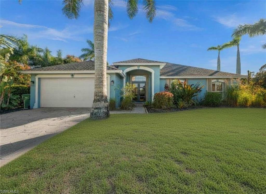 4 Colonial Drive Naples, FL 34112 - Photo 39 of 42 View of front of home with stucco siding, concrete driveway, an attached garage, and a front lawn