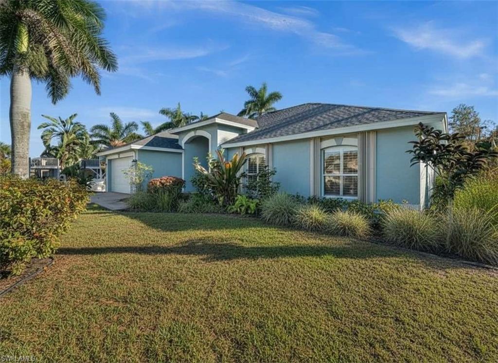 4 Colonial Drive Naples, FL 34112 - Photo 40 of 42 Ranch-style house with stucco siding, an attached garage, a front lawn, and a shingled roof