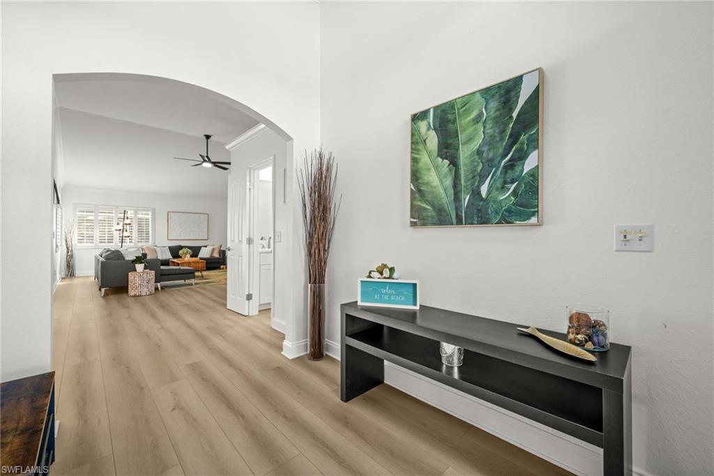 4 Colonial Drive Naples, FL 34112 - Photo 6 of 42 Corridor with arched walkways, wood finished floors, and ornamental molding