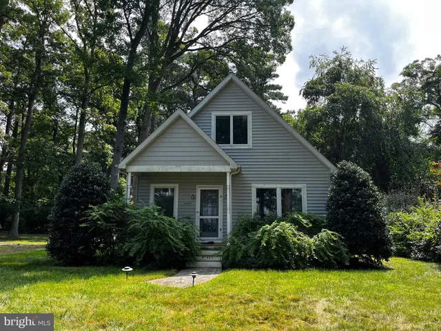 a front view of house with a garden