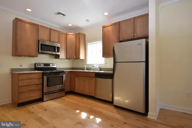 a kitchen with counter top space a sink cabinets and appliances