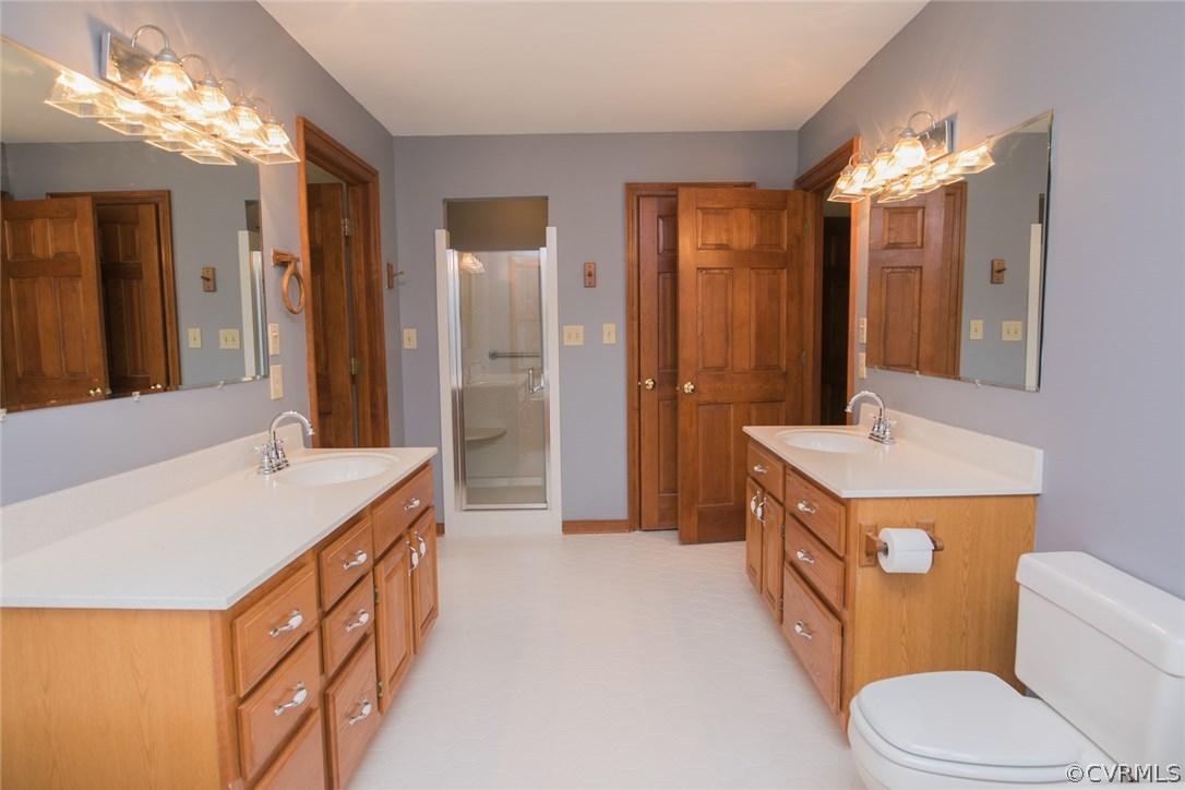 4002 Fraley Court Mechanicsville, VA 23111 - Photo 23 of 49 a bathroom with a sink a toilet and a large mirror