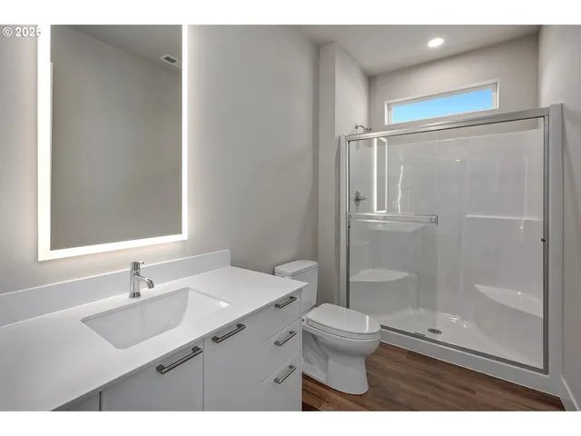 a bathroom with a sink a toilet a shower and a mirror