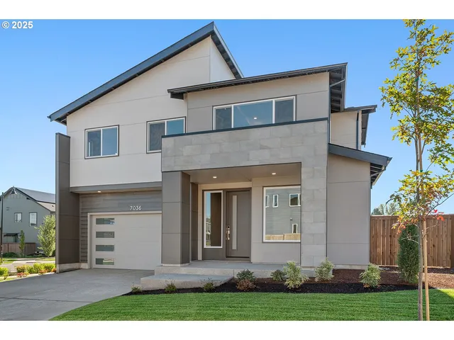 a front view of a house with a yard and garage