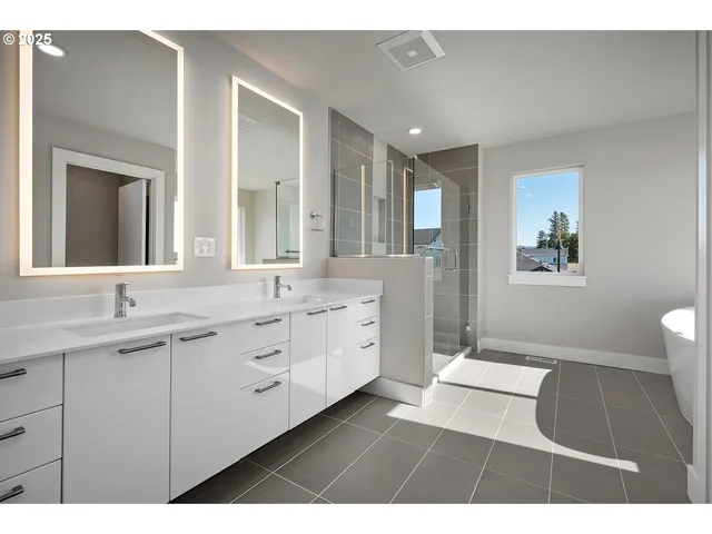 a spacious bathroom with a double vanity sink a mirror and a