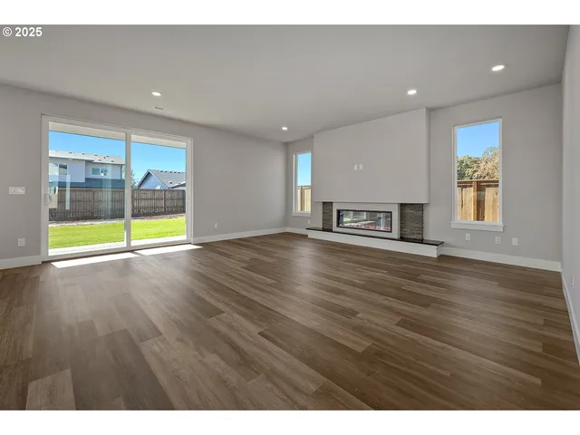 a view of empty room with wooden floor and fireplace