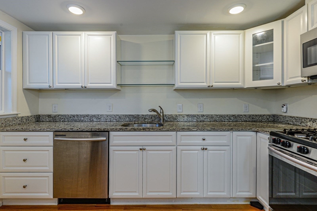 2 Mechanic Street, Unit 1 Newton, MA 02464 - Photo 2 of 14 a kitchen with granite countertop cabinets and wooden floor