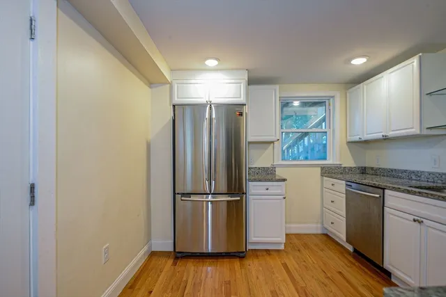 a kitchen with wooden floors and stainless steel appliances