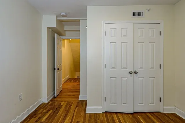 a view of a bedroom with wooden floor