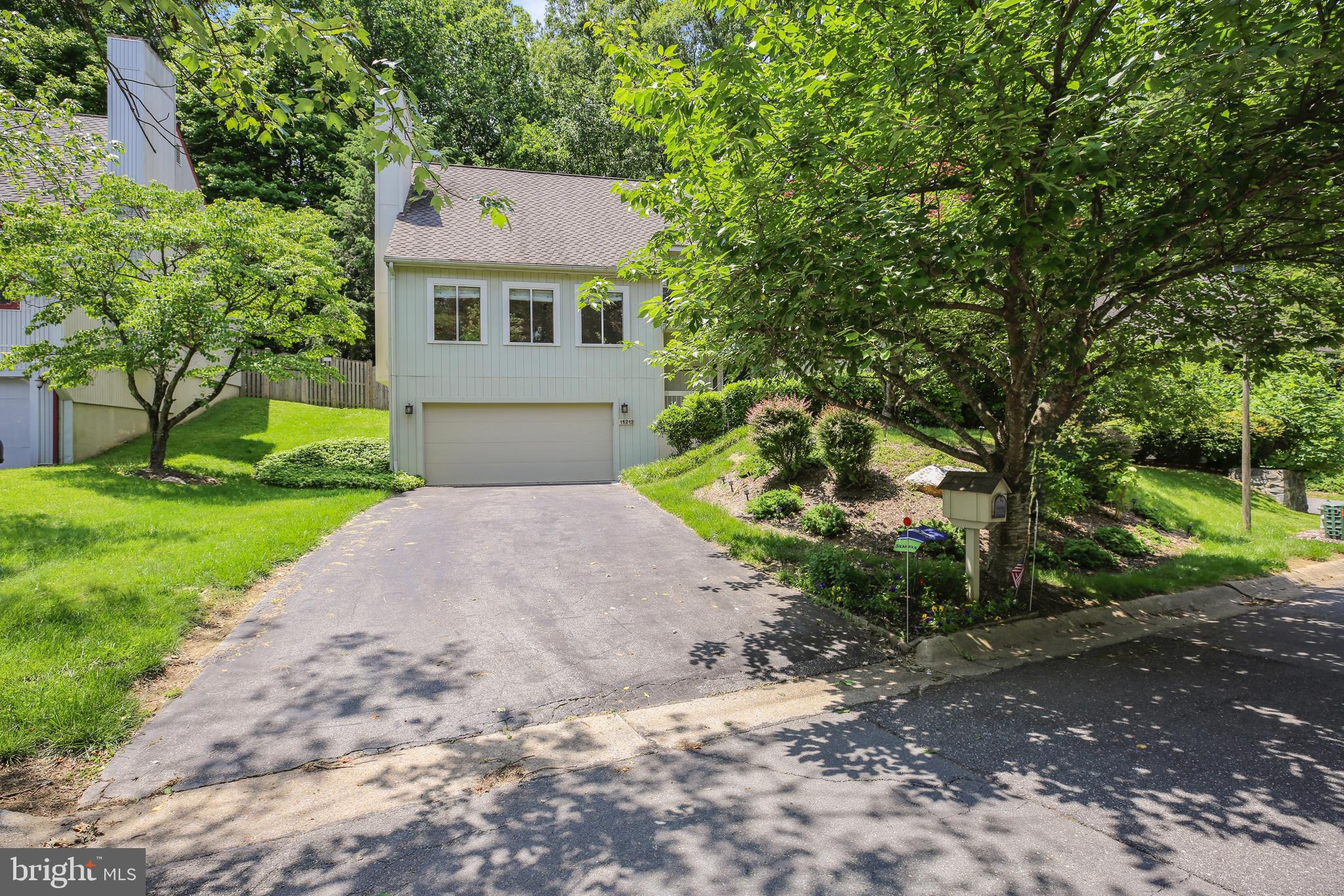 11212 Angus Place Potomac, MD 20854 - Photo 2 of 42 a front view of a house with a yard and garage