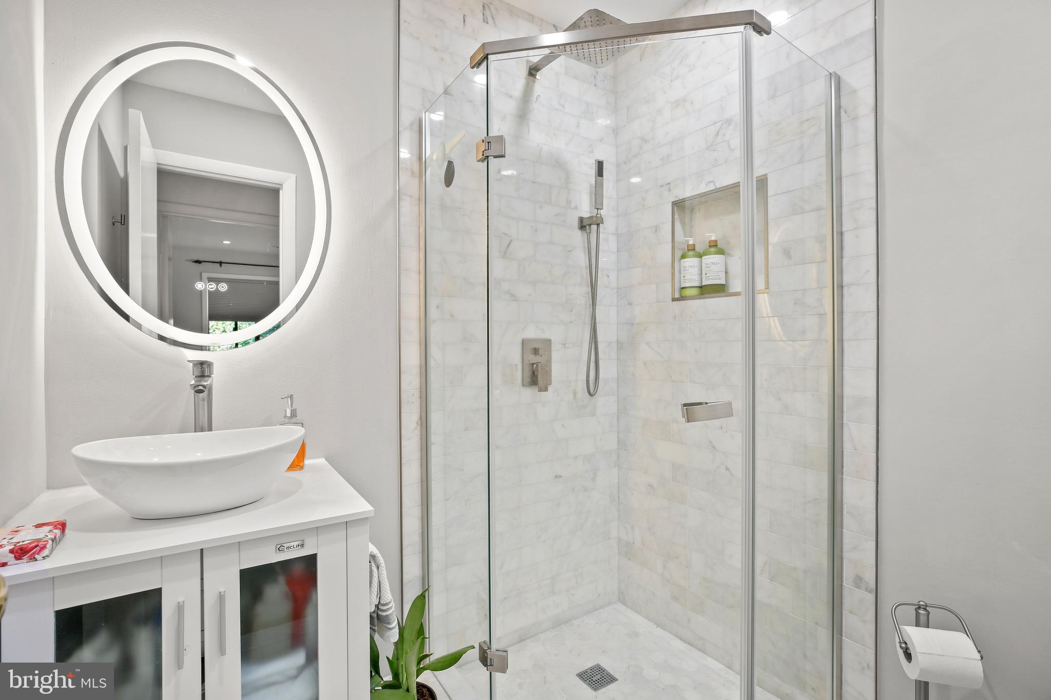 11212 Angus Place Potomac, MD 20854 - Photo 24 of 42 a bathroom with a sink a mirror and a shower