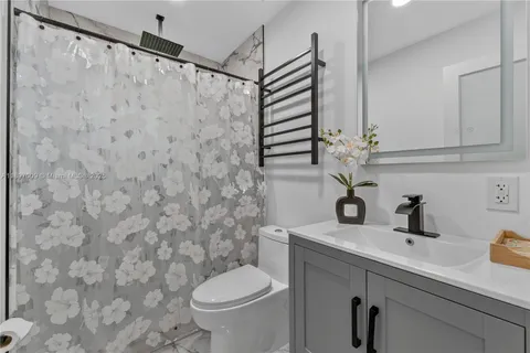 a bathroom with a sink a toilet and shower curtain