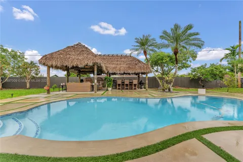 a view of a swimming pool with a lawn chairs under an umbrella