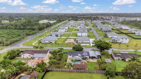 an aerial view of residential houses with outdoor space and swimming pool