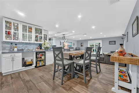 a kitchen with stainless steel appliances granite countertop a table and chairs with wooden floor