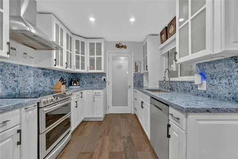 a kitchen with stainless steel appliances granite countertop a stove and a sink